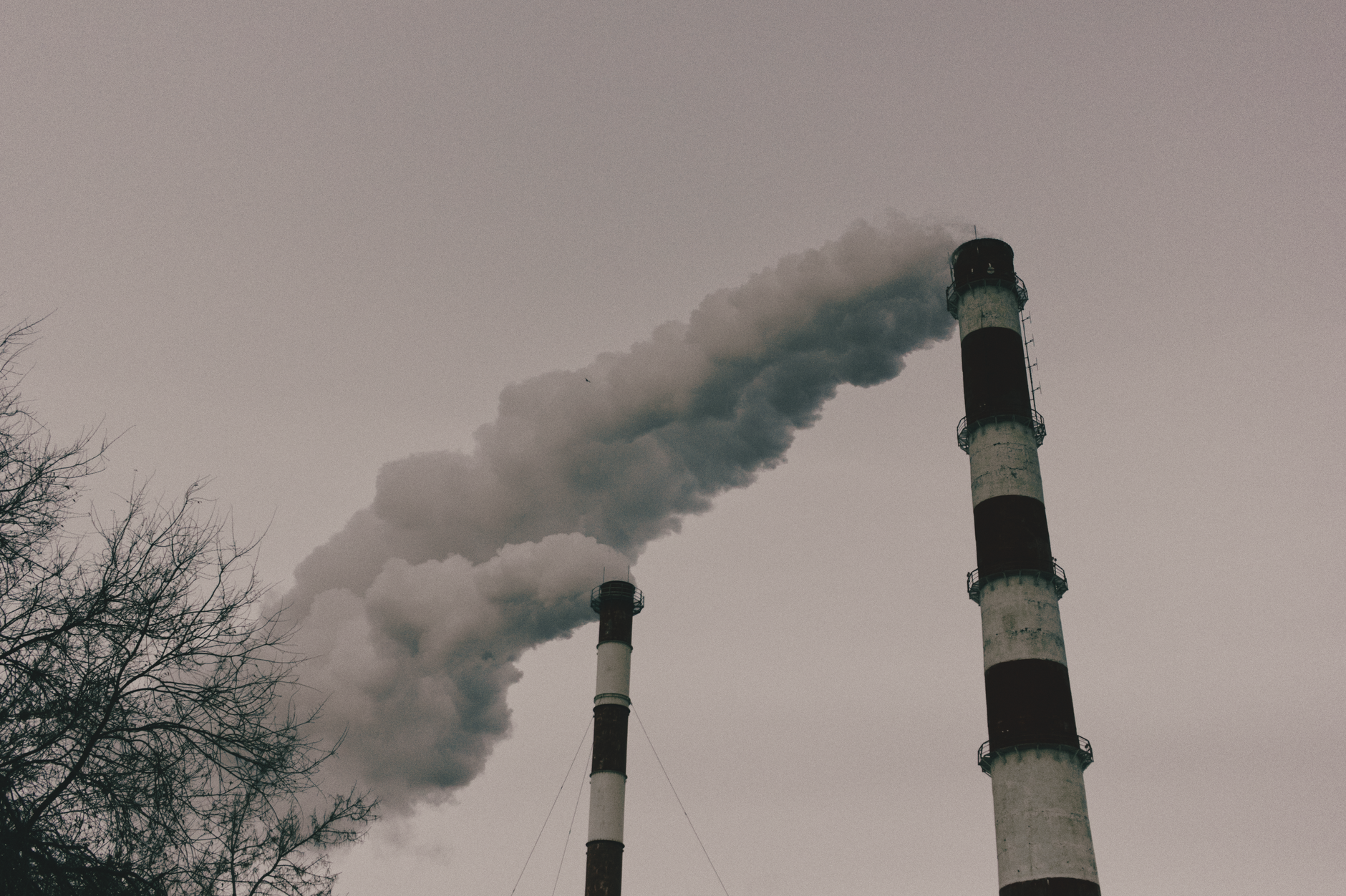 Environmental impact captured by smokestacks releasing plumes of smoke into the sky.