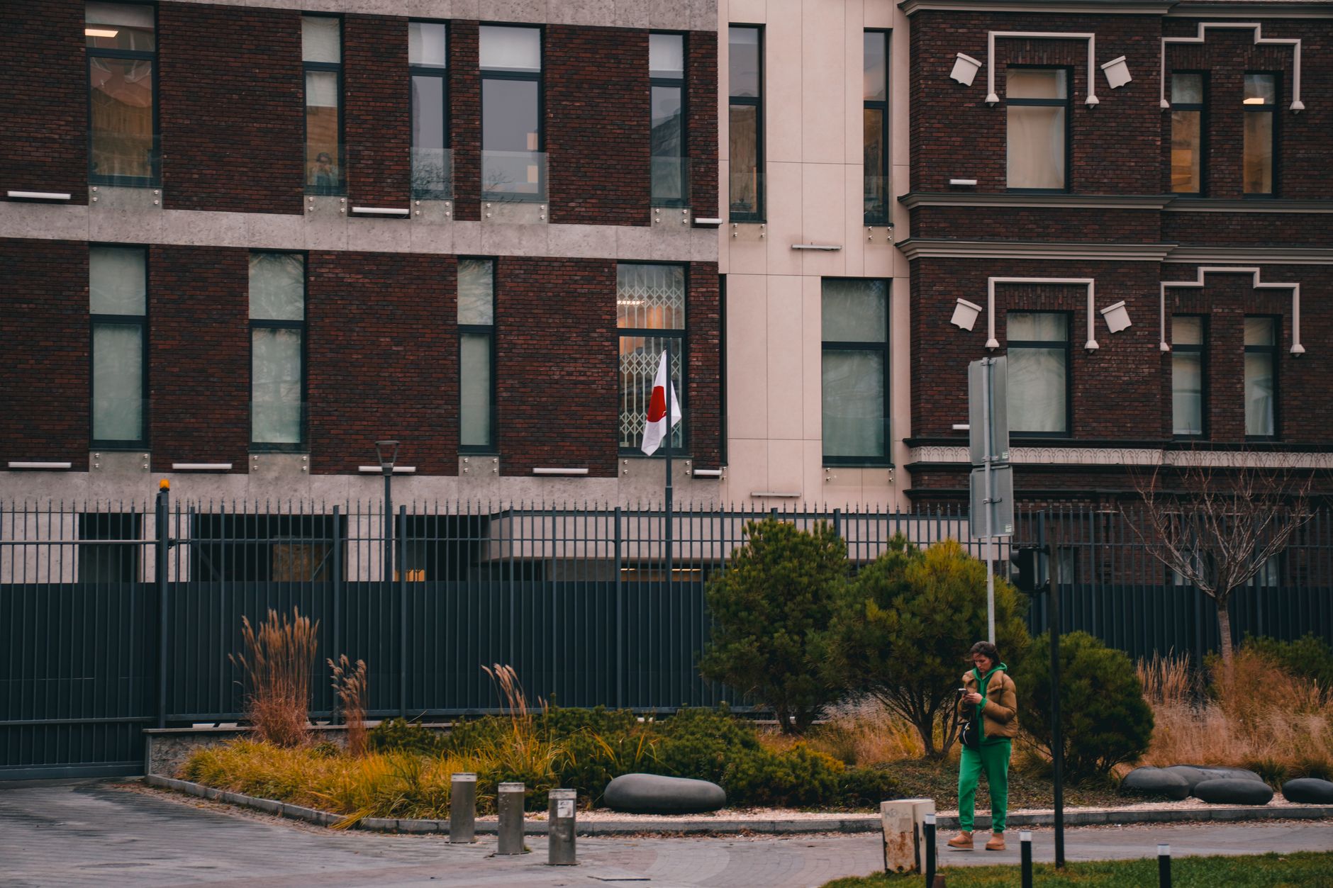 Exterior of the Japanese Embassy in Kyiv, featuring the national flag and urban landscape.