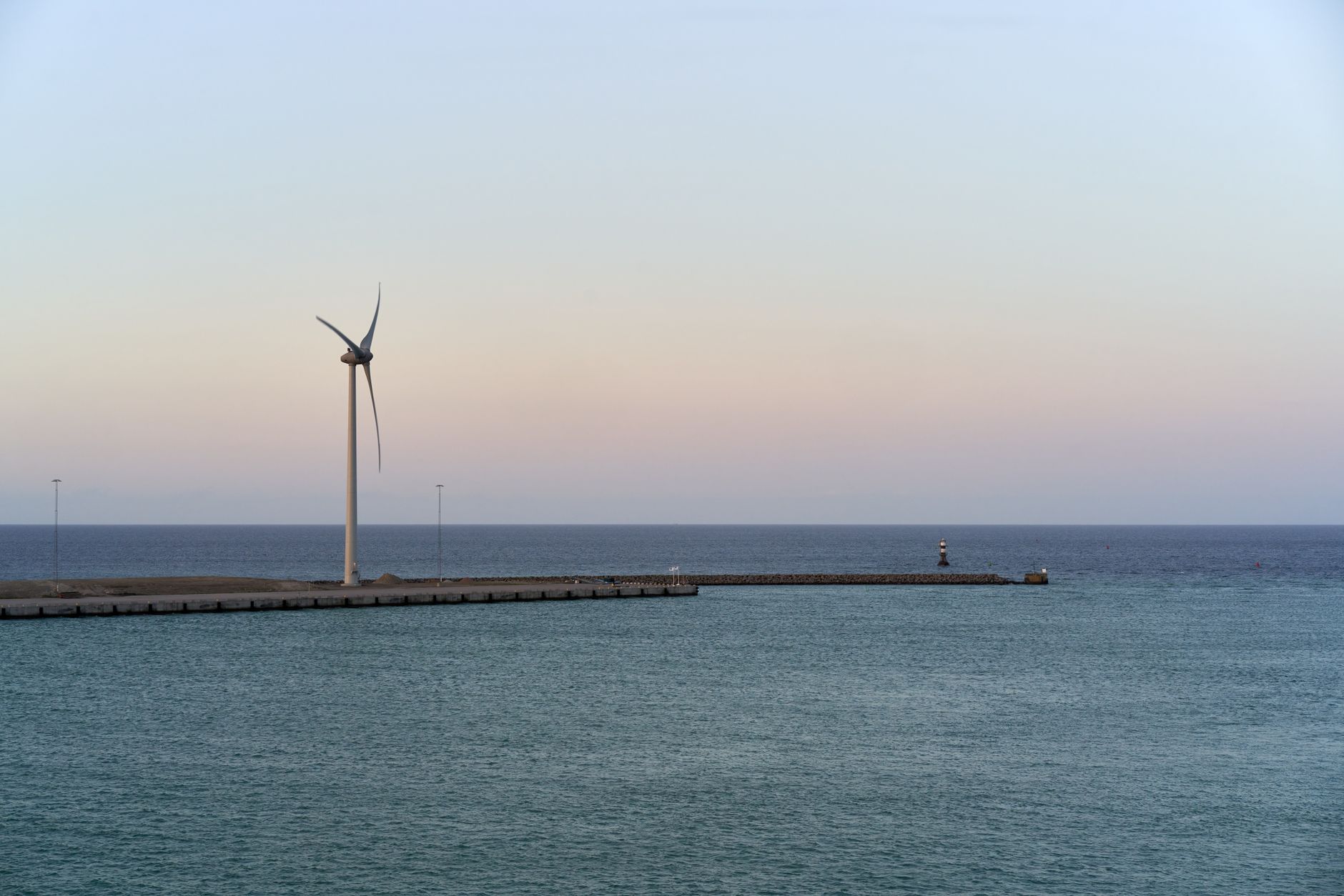 Serene coastal landscape with wind turbine at Trelleborg, Sweden. Modern clean energy concept at sunrise.