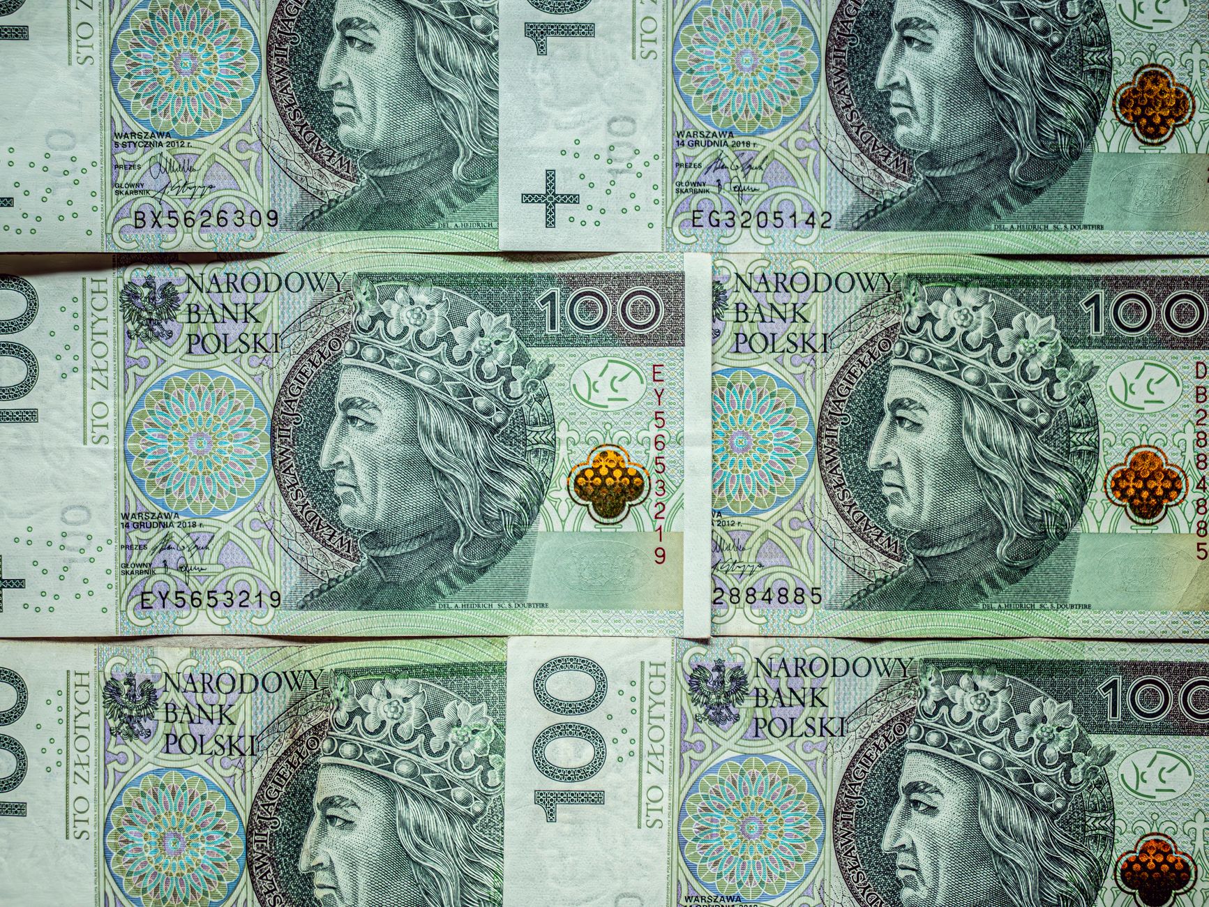Detailed stack of 100 Polish Zloty banknotes with King portrait.