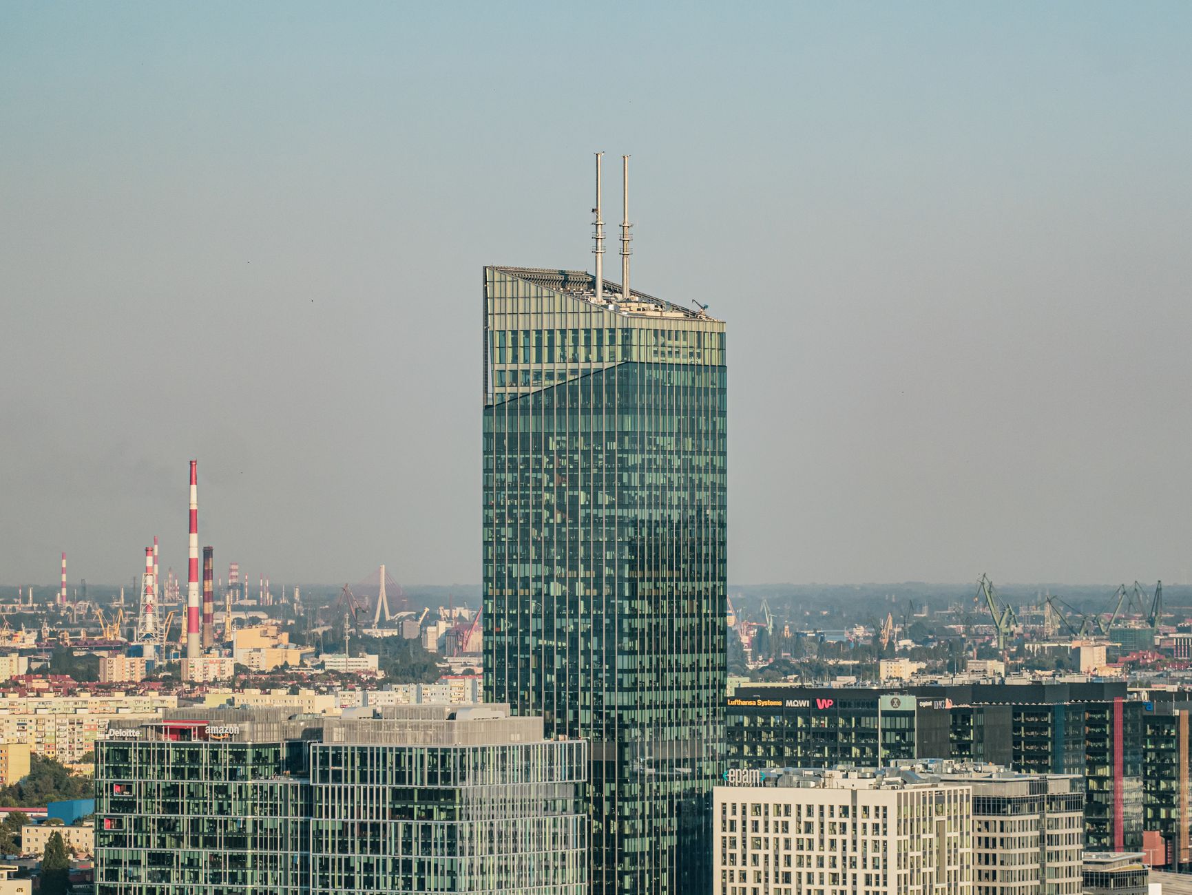 A striking view of a modern skyscraper amidst Gdańsk's cityscape, showcasing urban architecture.