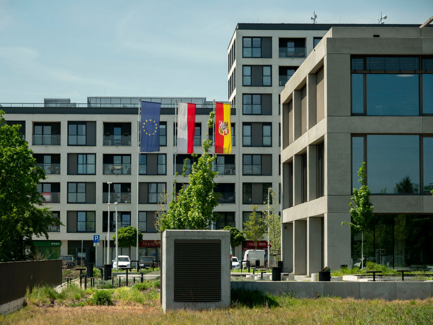 Contemporary architecture in Wrocław, Poland with flags of EU, Poland, and Wrocław.