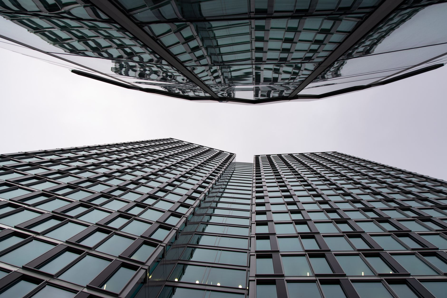 Dynamic view of mirrored skyscrapers in Warsaw's financial district, showcasing modern architecture.